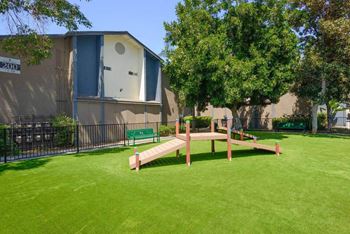 a park with a bench and trees in front of a building